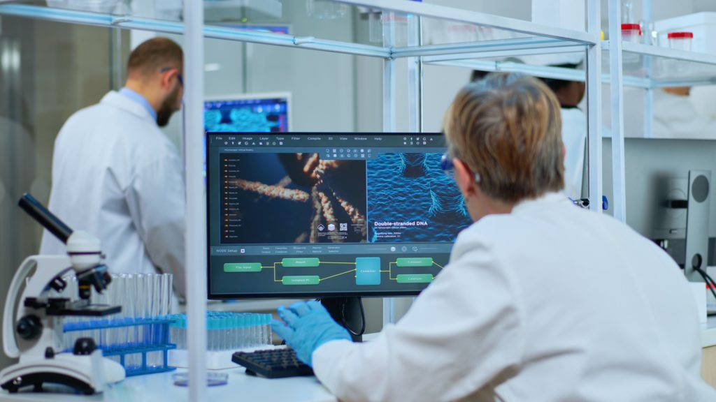 Medical research scientist typing codes on computer